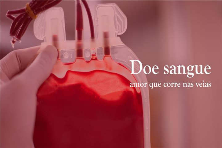 A imagem apresenta uma mão vestida com luva de procedimento médico na cor branca, segurando uma bolsa de coleta de sangue feita de material plástico transparente. Em seu interior contém um líquido de coloração avermelhada. No lado direito da bolsa de coleta de sangue há uma frase que diz: Doe sangue, amor que corre nas veias